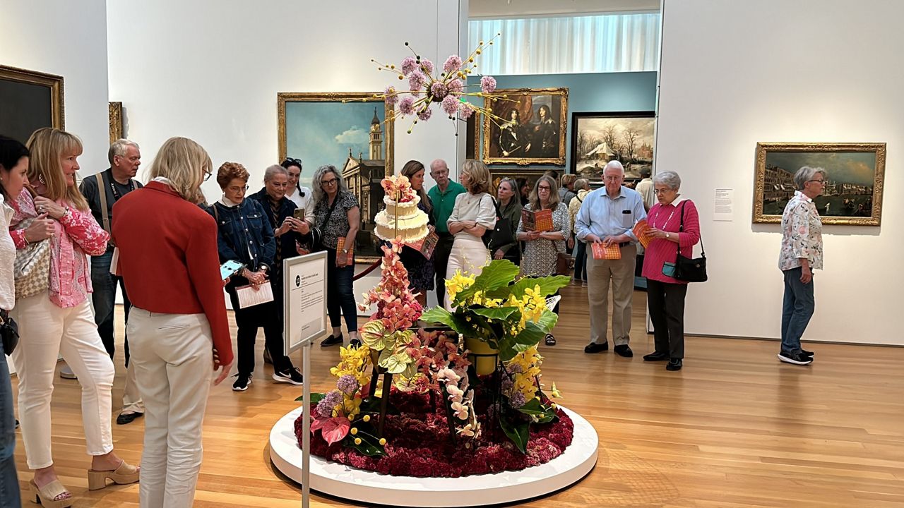 Visitors admire a floral arrangement at this year's Art in Bloom.