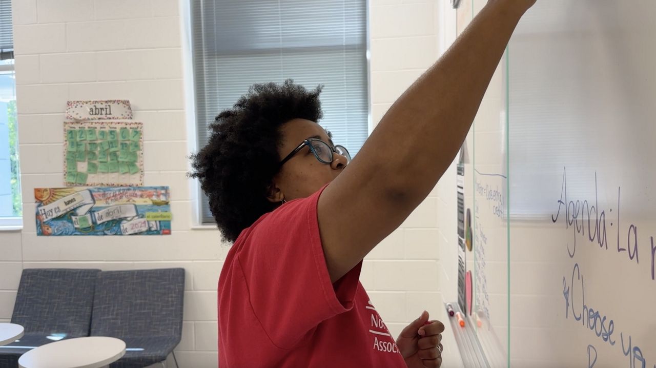 Ashley Smith, a Durham high school Spanish teacher, writes on a whiteboard.