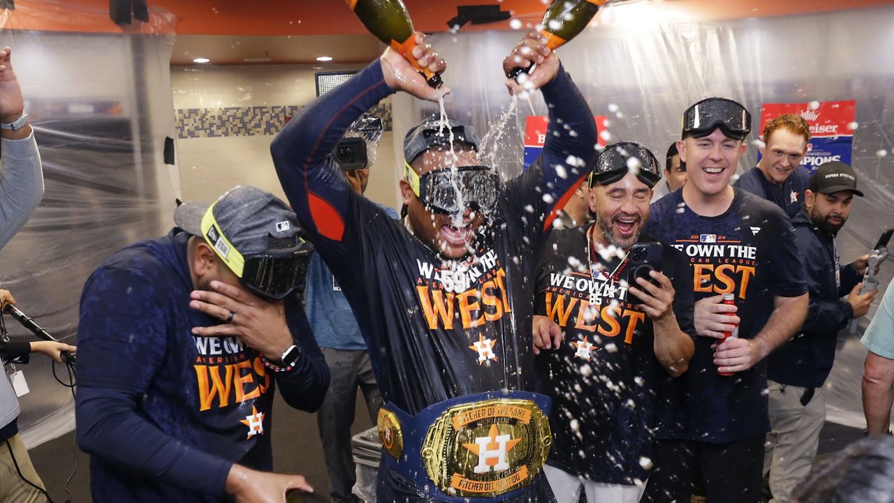 Houston Astros starting pitcher Framber Valdez, center, pours champagne on himself as the team celebrates in the clubhouse after defeating the Seattle Mariners 4-3 to clinch the AL West title after a baseball game Tuesday, Sept. 24, 2024, in Houston. (AP Photo/Michael Wyke)