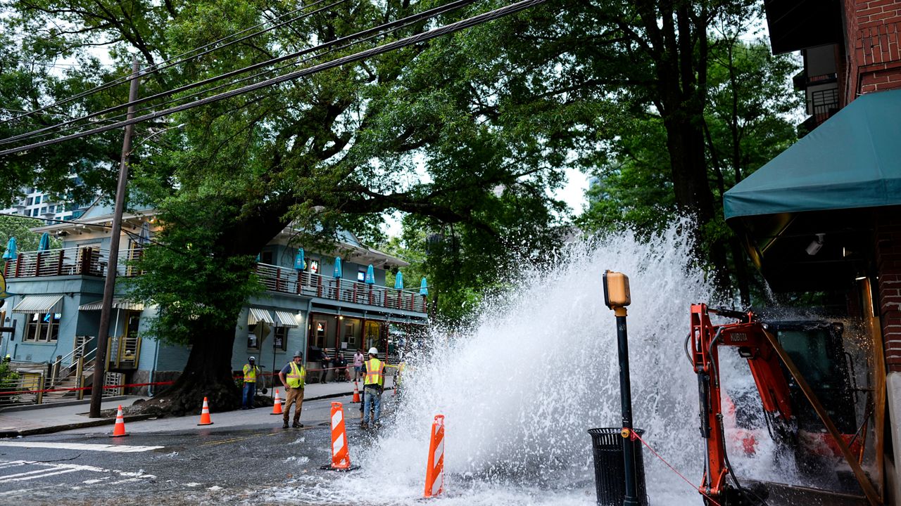 Water gushes out of a broken water transmission line in downtown Atlanta, Saturday, June 1, 2024. Much of Atlanta, including all of downtown, has been without water since Friday afternoon after crews began work to repair breaks on transmission lines in the downtown area. (AP Photo/Mike Stewart)