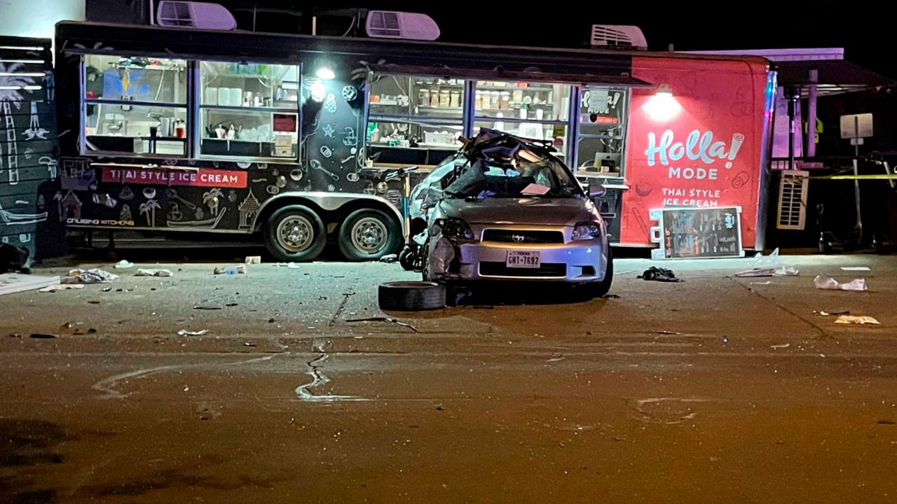 A damaged vehicle sits in front of a food truck following a collision in Austin, Texas on Friday, April 8, 2022. Authorities say multiple people were injured in the "major collision” involving pedestrians and two vehicles, one of which hit the food truck. (AP Photo/Acacia Coronado)