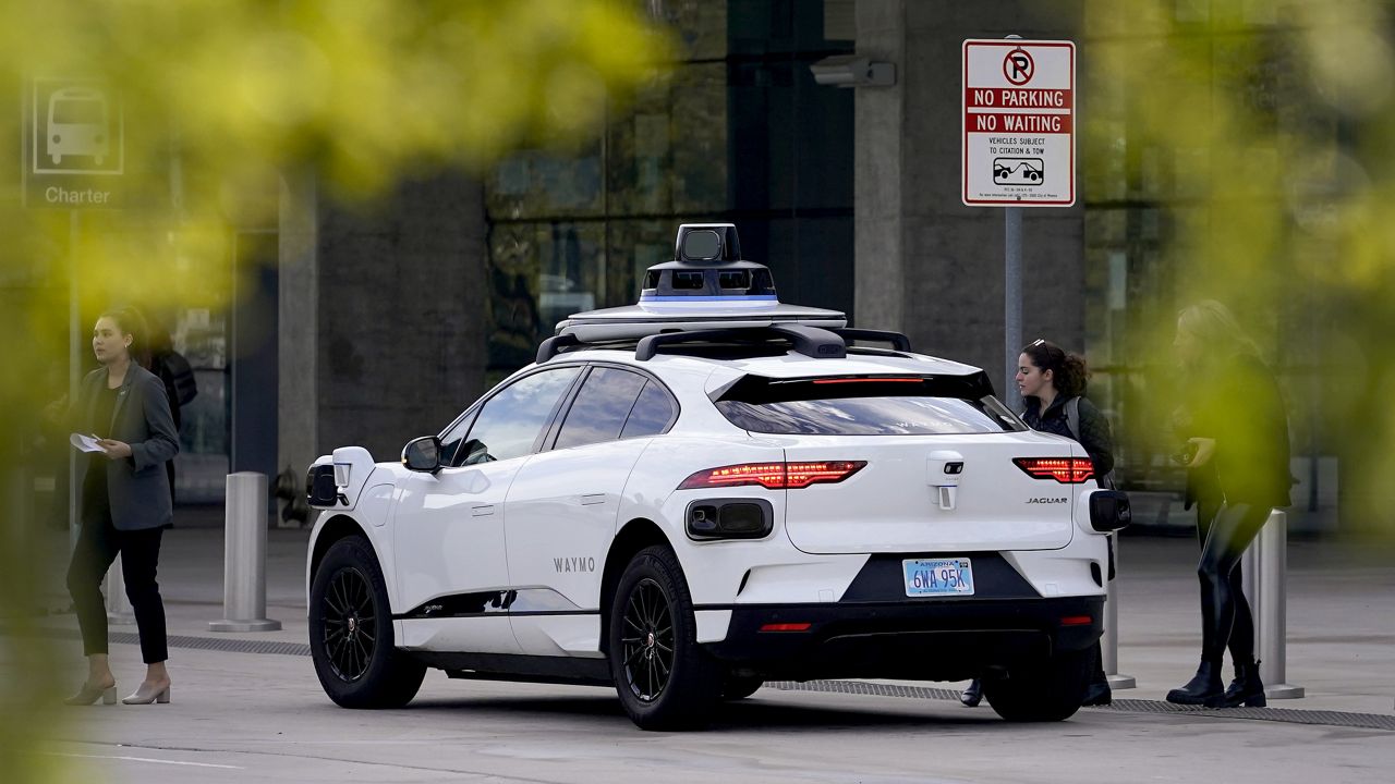 A Waymo self-driving vehicle sits curbside on Dec. 16, 2022, at the Sky Harbor International Airport Sky Train facility in Phoenix. (AP Photo/Matt York