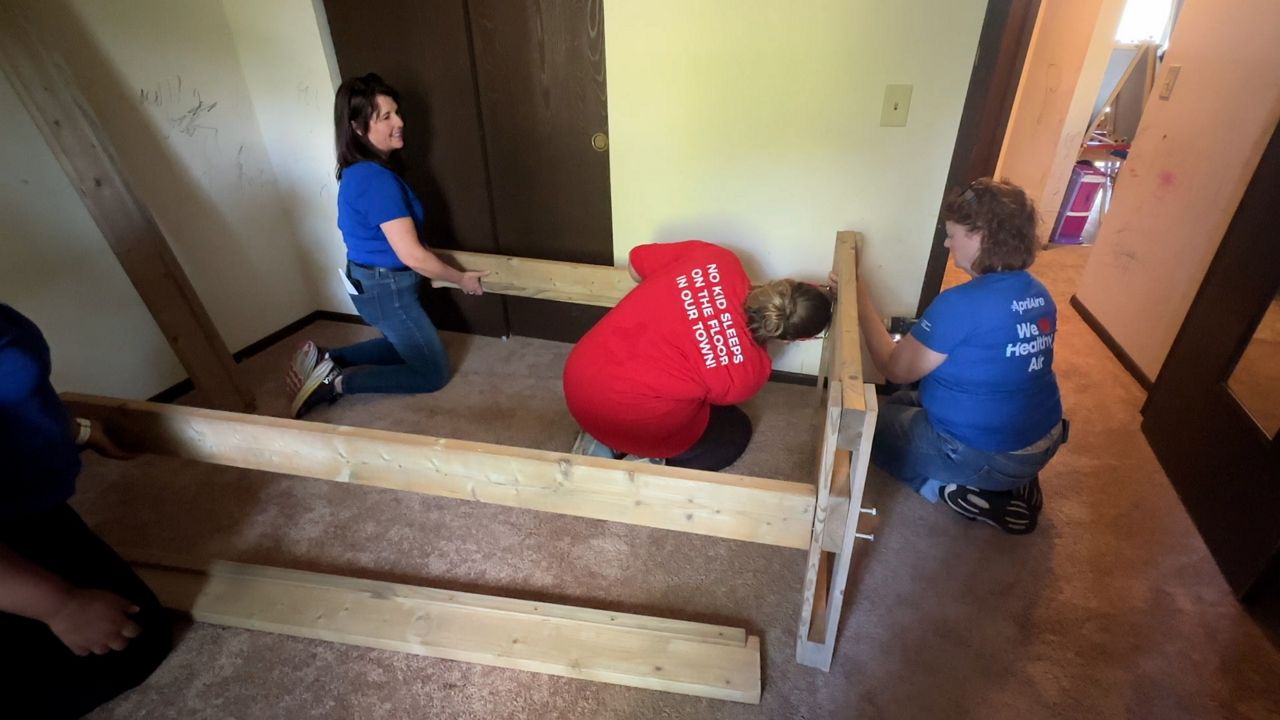 Volunteers with Sleep in Heavenly Peace build beds for two children. (Spectrum News 1/Natalie Sopyla)