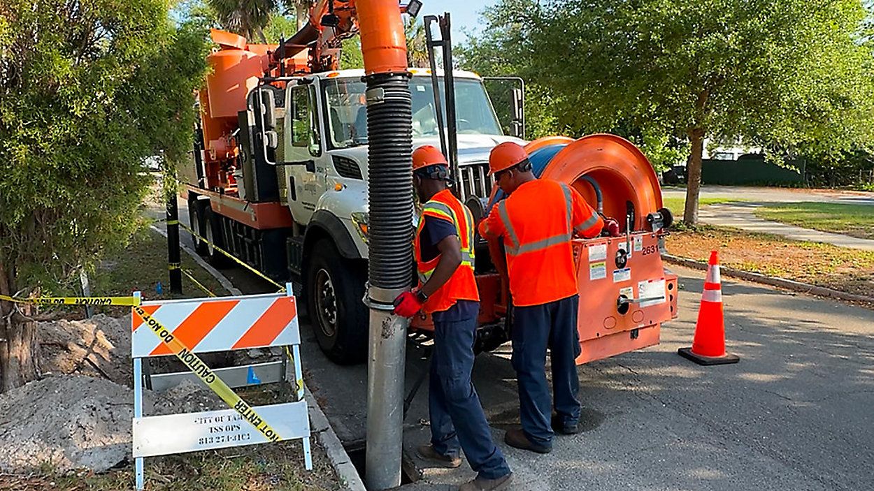 Workers in South Tampa have been using a three-cubic yard vacuum truck to clear out sludge and debris from storm drains, and digging out a drainage ditch to increase its capacity during heavy rainfall. (Spectrum News/Chris McDonald)