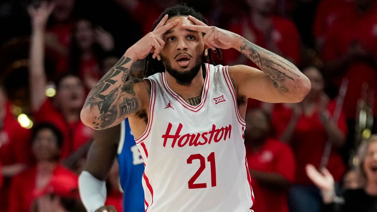 Houston guard Emanuel Sharp (21) reacts after making a 3-pointer during the first half of an NCAA college basketball game against the Brigham Young in Houston, Saturday, Jan. 4, 2025. (AP Photo/Ashley Landis)