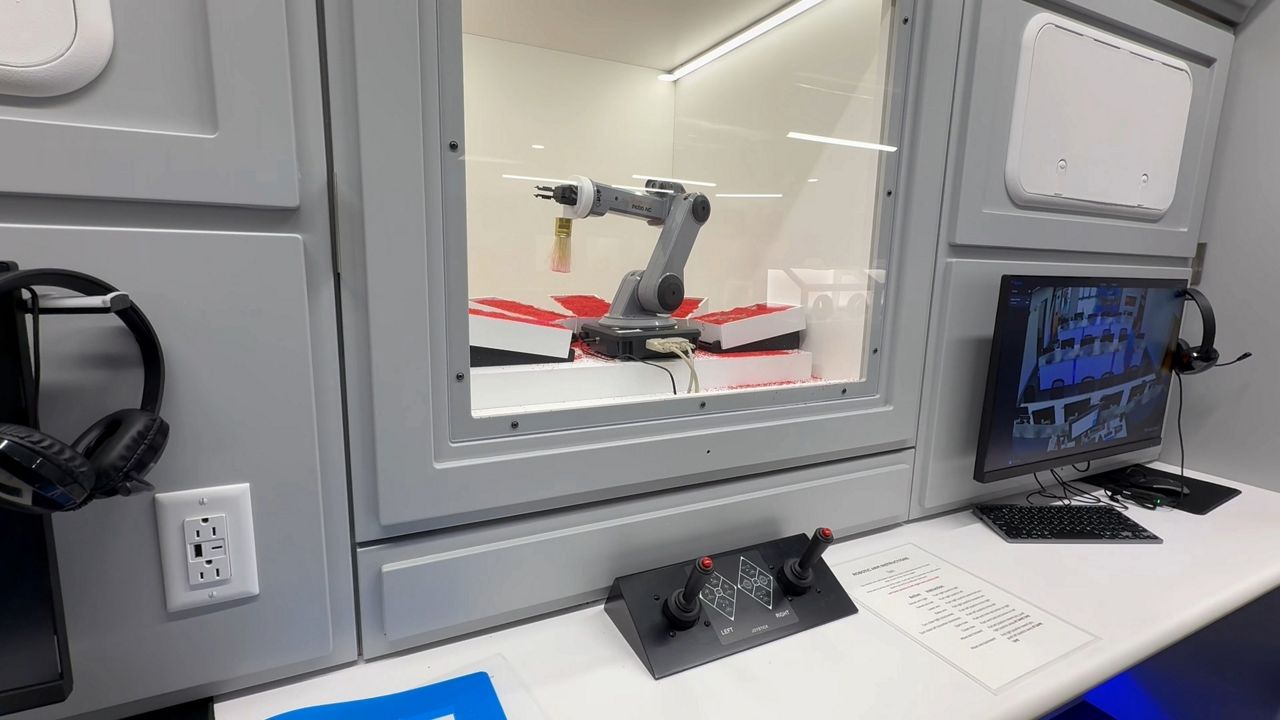 A robotic arm in the Challenger Learning Center’s “Spacecraft” room. (Spectrum News/David Ledford)