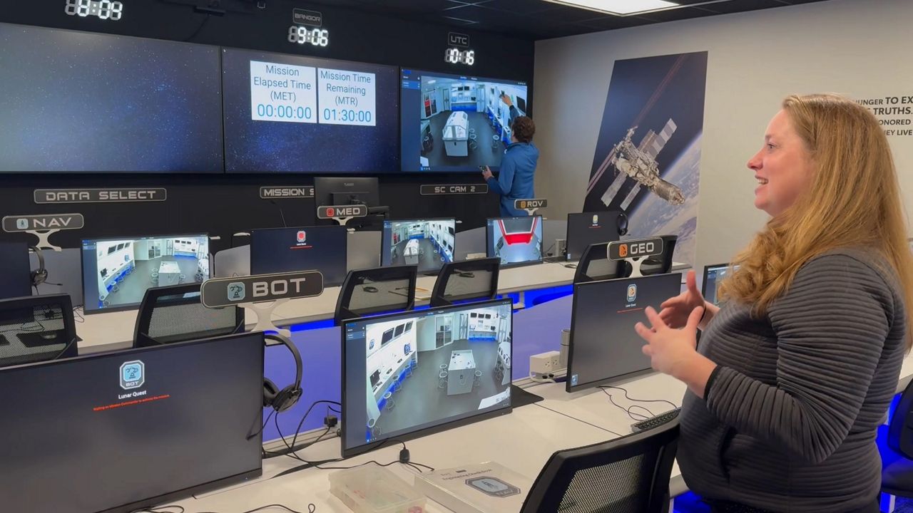 Challenger Learning Center Executive Director Kirsten Hibbard stands in the center’s upgraded “Mission Control” room. (Spectrum News/David Ledford)