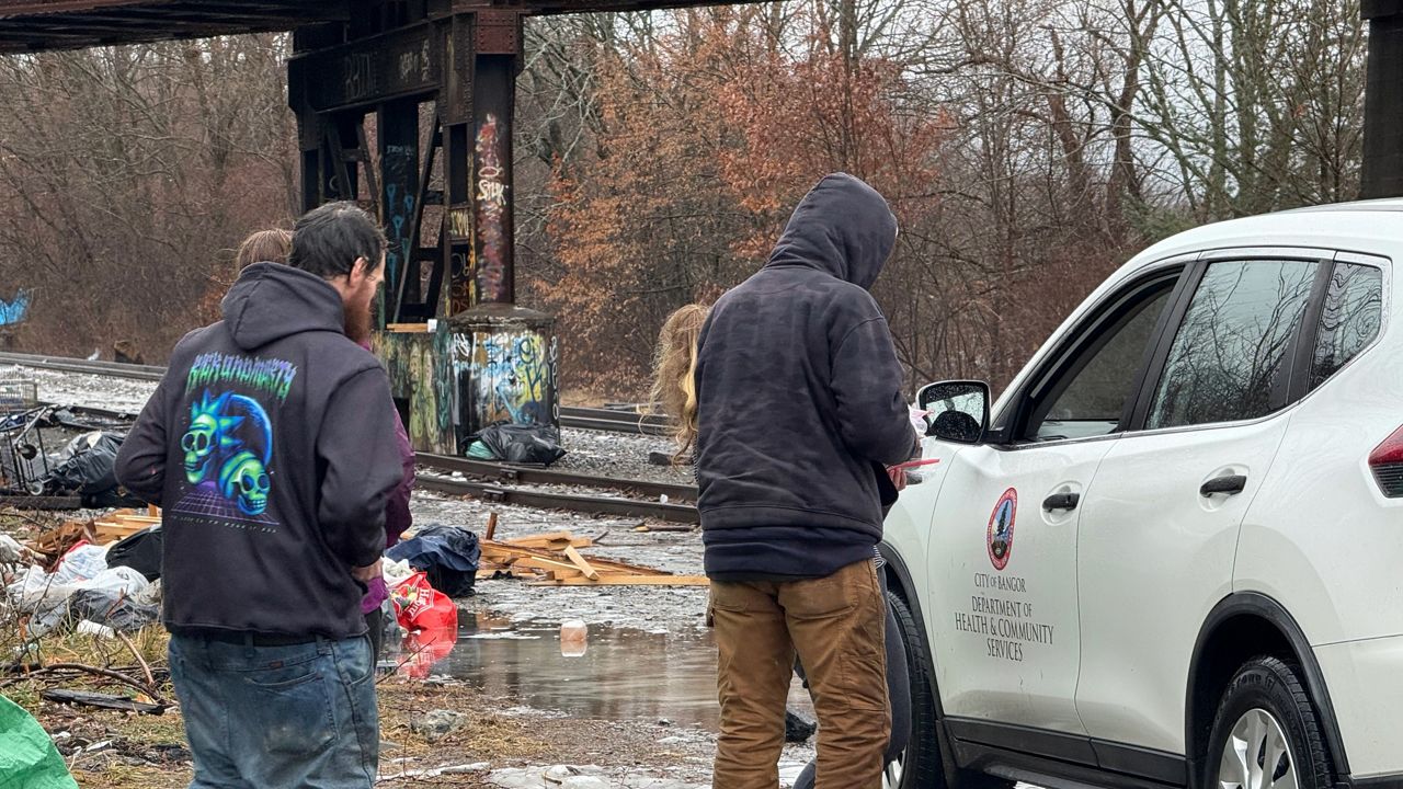 Encampment residents speak with an individual from Bangor Department of Health and Community Services. (Spectrum News/David Ledford)
