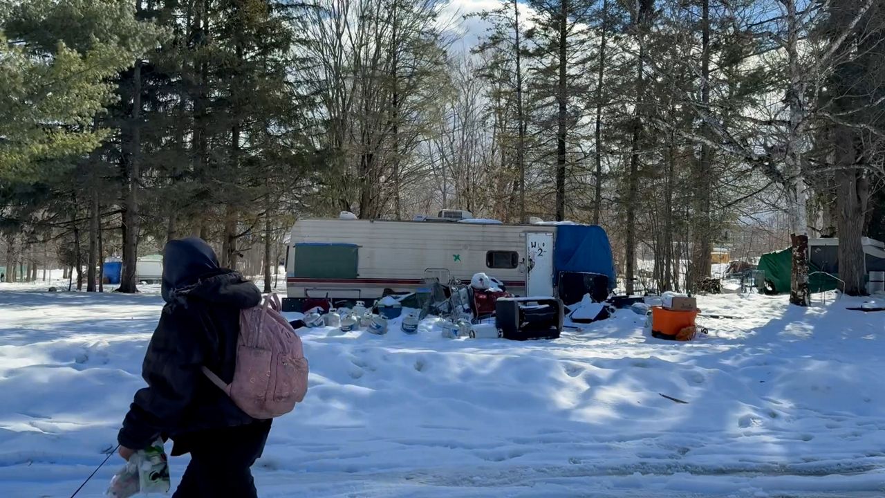 A passerby walks through Camp Hope Friday morning (David Ledford/Spectrum News)