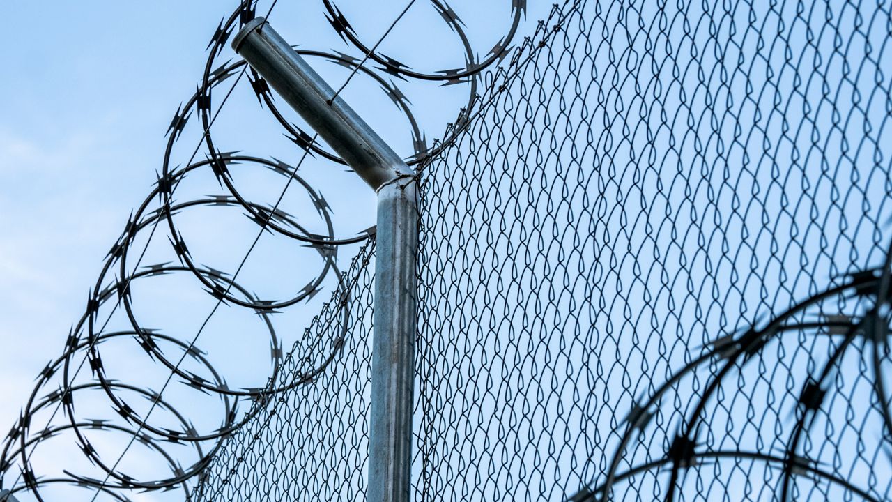 Barbed wire around a prison facility. 