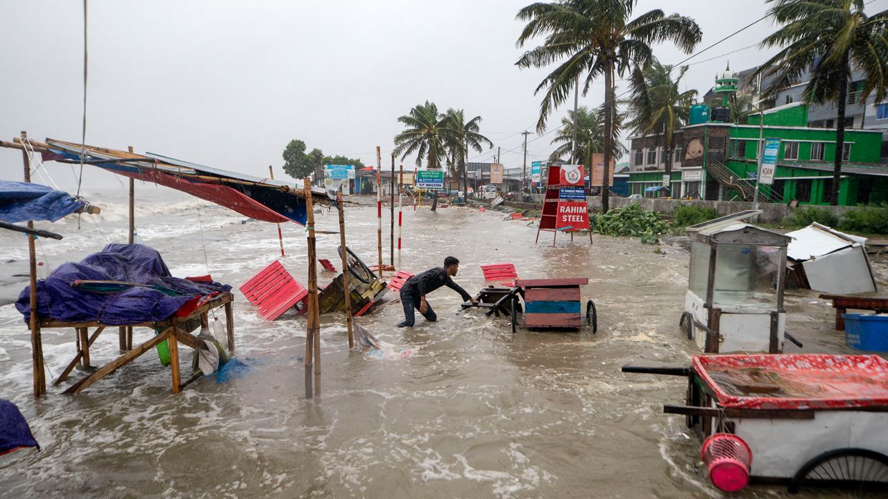 A man salvages a cart and other material as water flows on to the Kuakata beach on the coast of Bay of Bengal caused by the advancing Cyclone Remal in Barisal, Bangladesh, Sunday, May 26, 2024. (AP Photo/Abdul Goni)