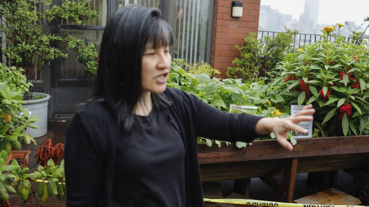 Beatrice Chen, executive director of Immigrant Social Services, walks by the garden of the Senior Living Chung Pak complex, Thursday, Aug. 8, 2024, in New York. (AP Photo/Kena Betancur)