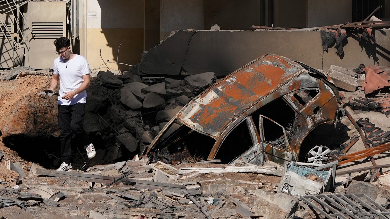 A man walks on rubble at the site of an Israeli airstrike in Beirut's southern suburbs, Sunday, Sept. 29, 2024. (AP Photo/Hassan Ammar)