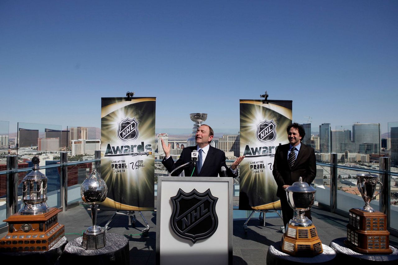 NHL Commissioner Gary Bettman (R) listens to a question during a