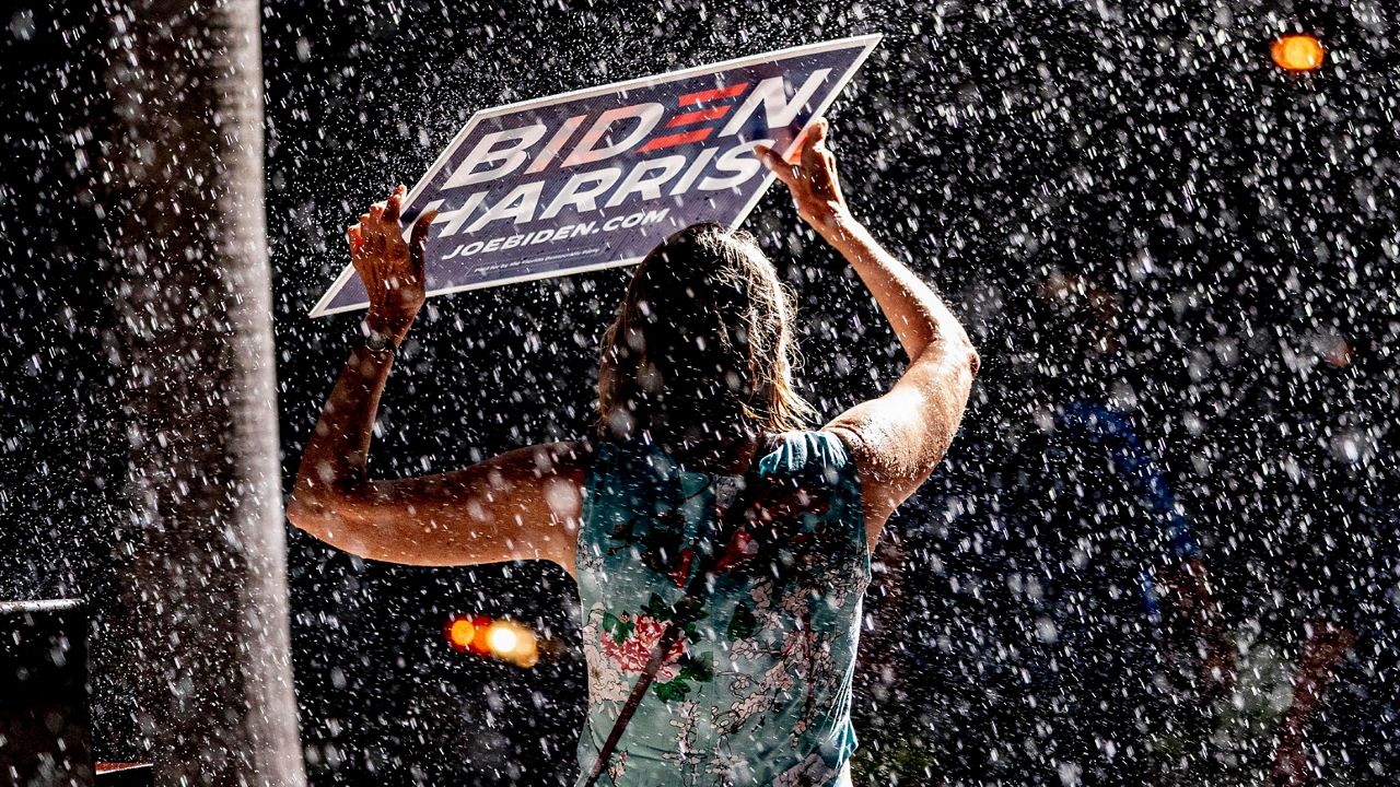 Members of the audience take cover as a sudden downpour cuts short a rally for Democratic presidential candidate former Vice President Joe Biden at the Florida State Fairgrounds in Tampa, Fla., Thursday, Oct. 29, 2020. (Andrew Harnik/AP)