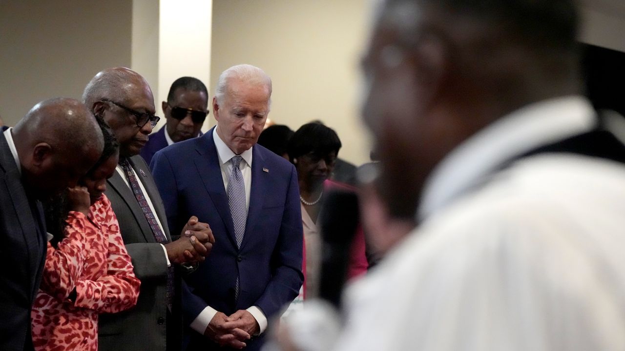 President Joe Biden, fourth left, bows his head as Reverend Dr. Jamey O. Graham Sr., in foreground at right, speaks at St. John Baptist Church, in Columbia, S.C., on Sunday, Jan. 28, 2024. To the left of Biden is Rep. Jim Clyburn, D-S.C. (AP Photo/Jacquelyn Martin)