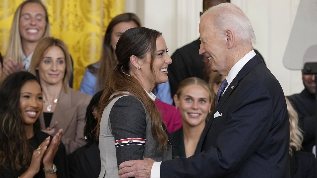 President Joe Biden talks with Ali Krieger, a member of the 2023 NWSL championship NJ/NY Gotham FC team, during an event in the East Room of the White House in Washington, Monday, Sept. 23, 2024, to welcome the team and celebrate their championship. (AP Photo/Susan Walsh)