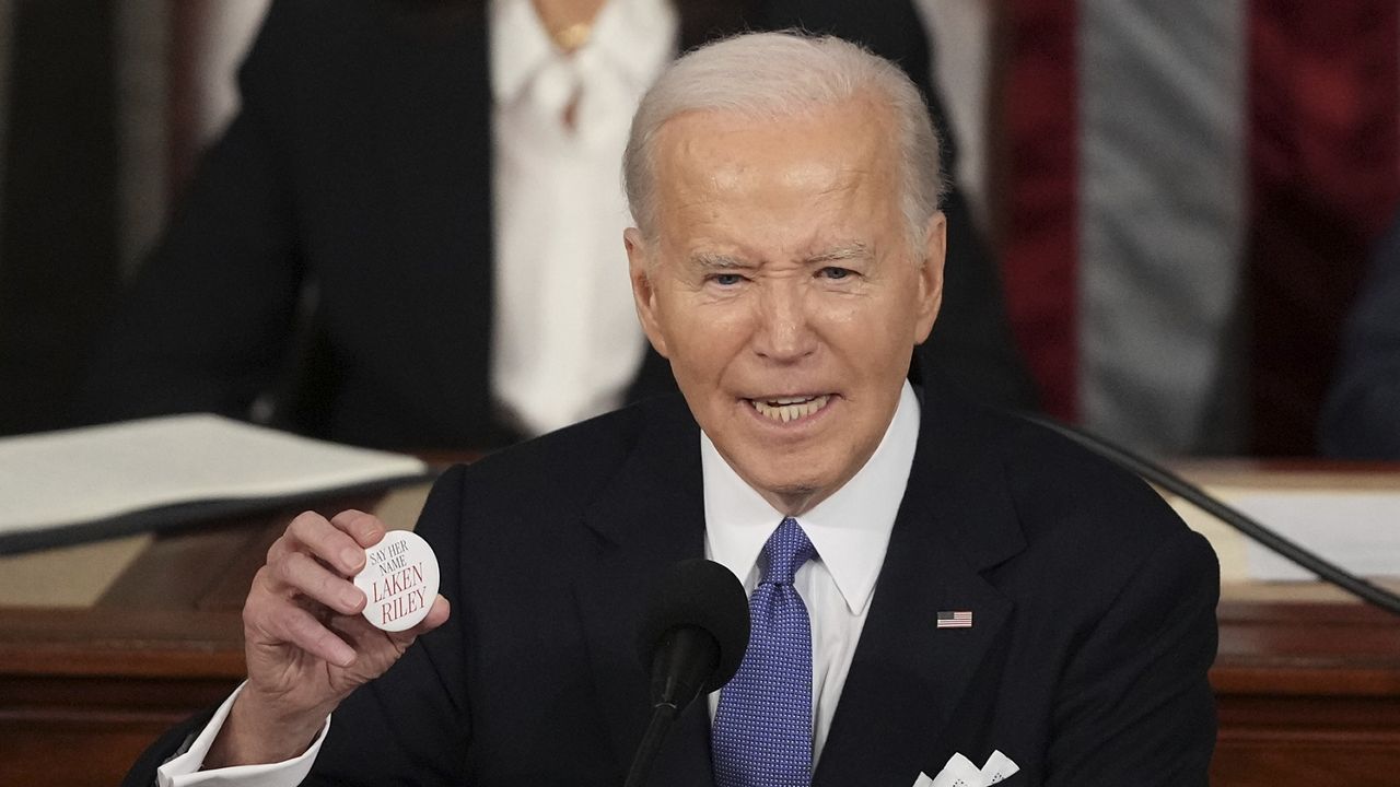 President Joe Biden holds up a Laken Riley button as he delivers the State of the Union address to a joint session of Congress at the U.S. Capitol, Thursday March 7, 2024, in Washington. (AP Photo/Andrew Harnik)