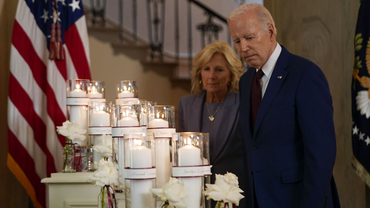 President Joe Biden, accompanied by first lady Jill Biden, pauses at a memorial display before he speaks on the one year anniversary of the school shooting in Uvalde, Texas, at the White House in Washington, Wednesday, May 24, 2023. (AP Photo/Andrew Harnik)