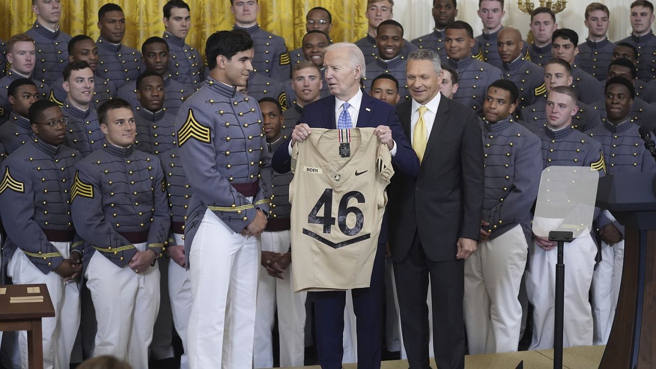 President Joe Biden is presented a team jersey by team captain Jimmy Ciarlo, as head coach Jeff Monken, right, looks on, during an event to present the Commander-in-Chief's Trophy to the United States Military Academy Army Black Knights, in the East Room of the White House, Monday, May 6, 2024, in Washington. (AP Photo/Evan Vucci)