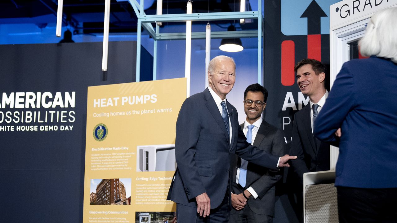 President Joe Biden laughs with Vincent Romanin, second from right, CEO of Gradient Comfort, a company that produces a window air conditioner with heat pump technology as he tours demonstrations during White House Demo Day, showcasing science and technology that have resulted from infrastructure investments, Tuesday, Nov. 7, 2023, at The Showroom in Washington. (AP Photo/Andrew Harnik)