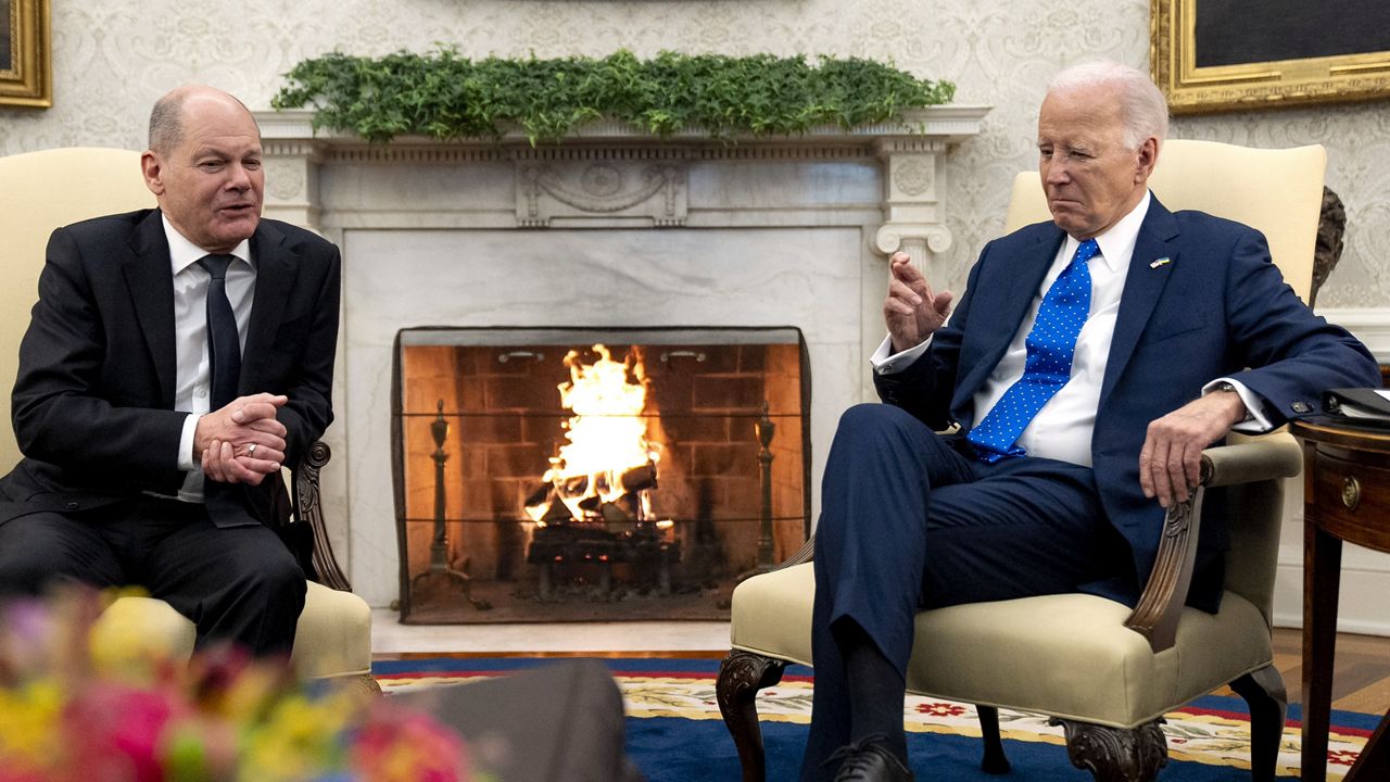 President Joe Biden, right, crosses his fingers in response to a comment from German Chancellor Olaf Scholz in the Oval Office of the White House, Friday, Feb. 9, 2024, in Washington. (AP Photo/Andrew Harnik)