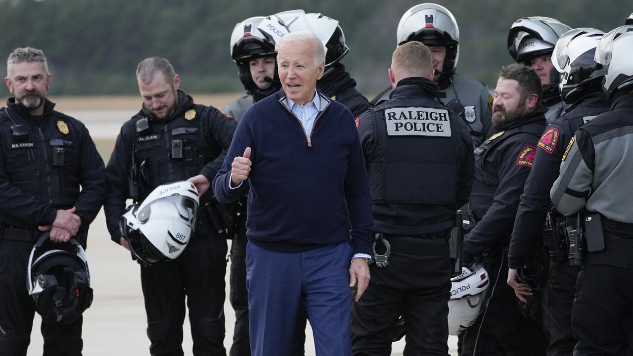President Joe Biden posed for a photograph with the police who escorted his motorcade, before boarding Air Force One at Raleigh-Durham International Airport in Cary, N.C., Thursday, Jan. 18, 2024, enroute to Washington. (AP Photo/Manuel Balce Ceneta)