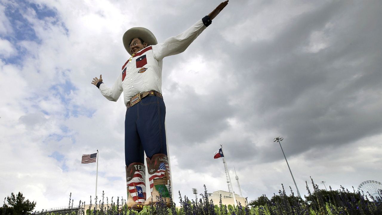 Bluebonnets, the state flower of Texas, surround Big Tex as storm clouds move in above, Friday, Sept. 27, 2013, in Dallas. (AP Photo/Tony Gutierrez, File)