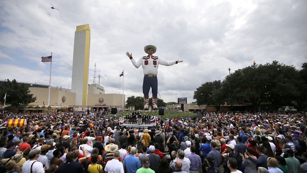 Thousands of visitors to the State Fair of Texas stand in the fair grounds circle watching an official ceremony where the 55-foot-tall Big Tex fair symbol welcomed everyone to the fair, Friday, Sept. 27, 2013, in Dallas. (AP Photo/Tony Gutierrez)