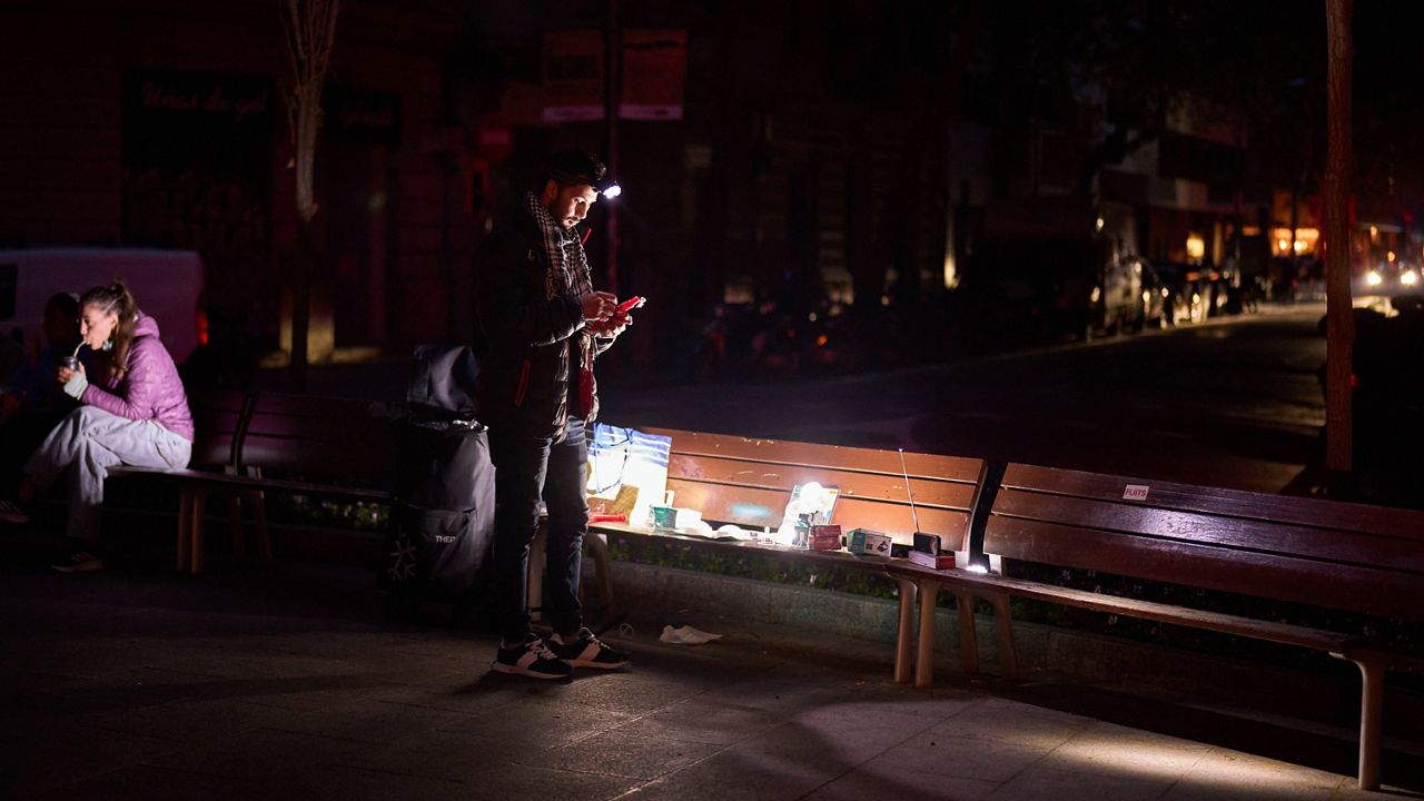 A man sells battery-powered radios and torches on a Barcelona street during the blackout in Barcelona, Spain, Tuesday, April 29, 2025. (AP Photo/Emilio Morenatti)
