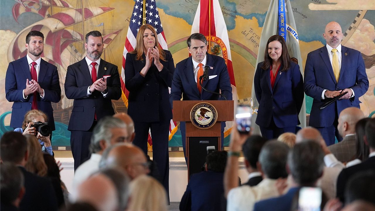 Audience members give a standing ovation as Acting Attorney General Todd Blanche, center, speaks at an event where federal prosecutors announced charges against former Cuban President Raul Castro in the 1996 downing of civilian planes operated by Miami-based exiles, Wednesday, May 20, 2026, in Miami. (AP Photo/Rebecca Blackwell)