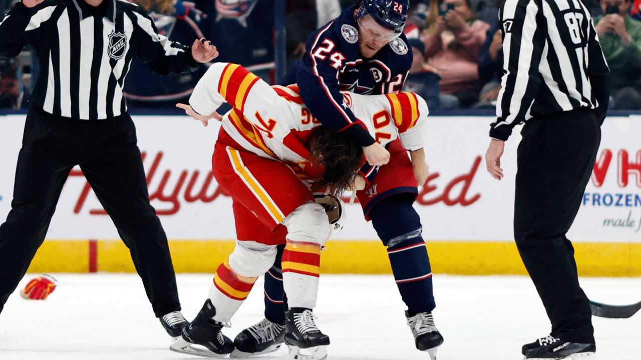 Columbus Blue Jackets forward Mathieu Olivier (24) fights with Calgary Flames forward Ryan Lomberg (70) during the second period of an NHL hockey game in Columbus, Ohio, Friday, Nov. 29, 2024. 