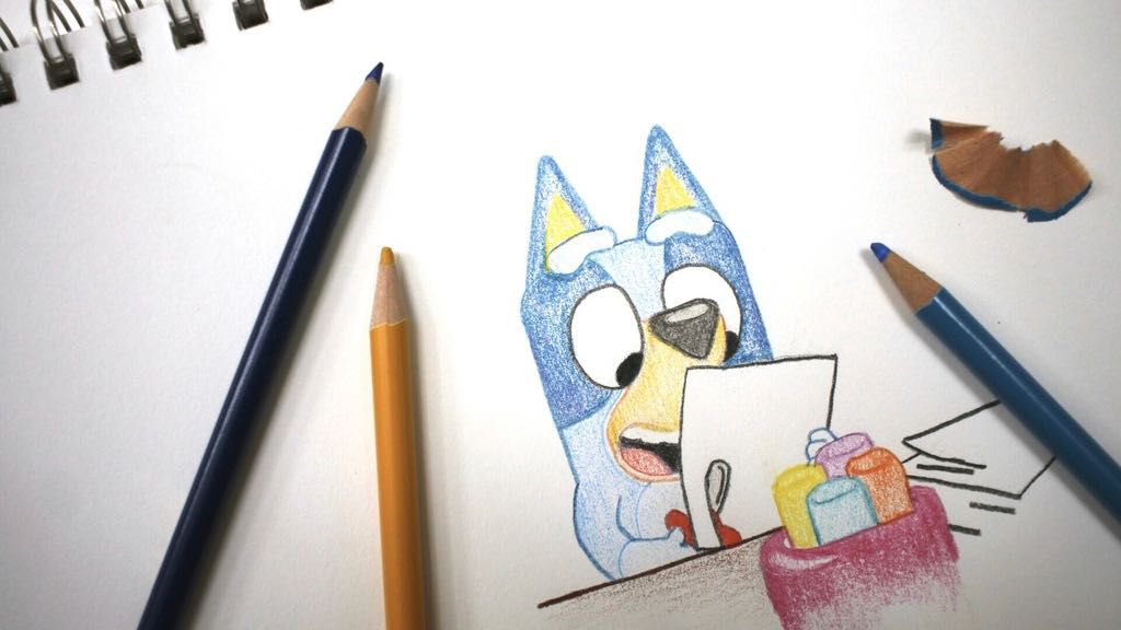 Colored pencils sit around a drawing of "Bluey" the Australian kids' television program character on a sketch pad Friday, April 19, 2024, in Phoenix, Ariz. (AP Photo/Cheyanne Mumphrey)