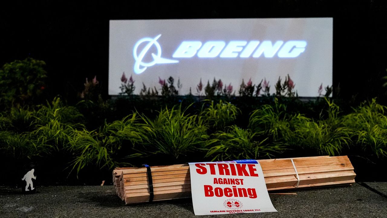 Signs and firewood sit in front of a Boeing sign as employees picket after union members voted overwhelmingly to reject a contract offer and go on strike Friday, Sept. 13, 2024, outside the company's factory in Renton, Wash. (AP Photo/Lindsey Wasson)