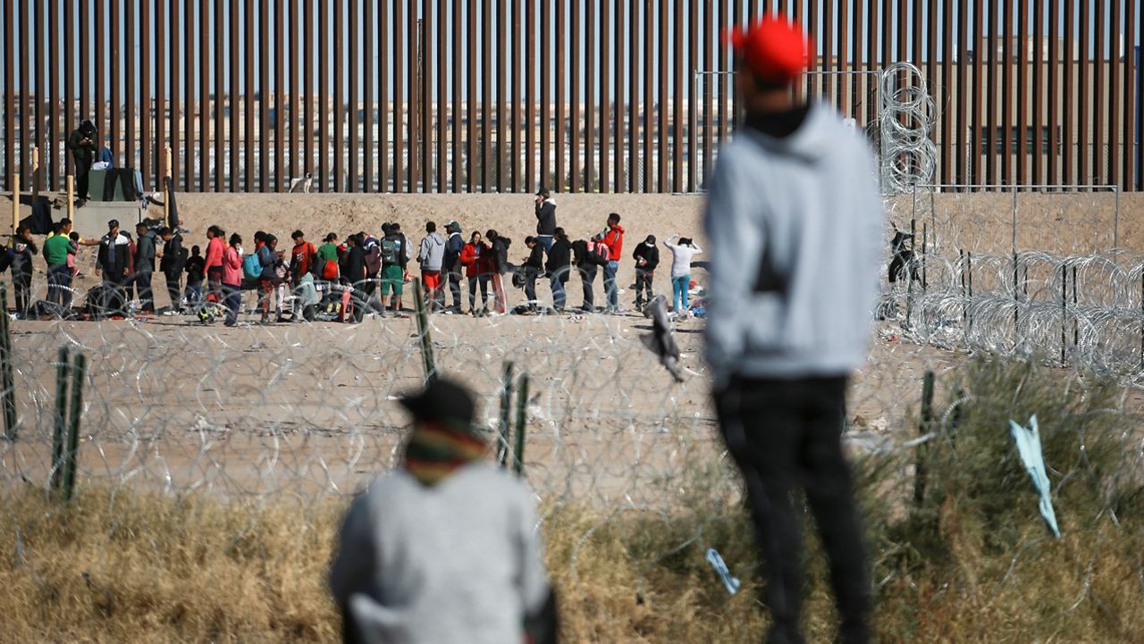 Migrants line up at the U.S. border wall after being detained by U.S. immigration authorities, seen from Ciudad Juarez, Mexico, Wednesday, Dec. 27, 2023. (AP Photo/Christian Chavez)