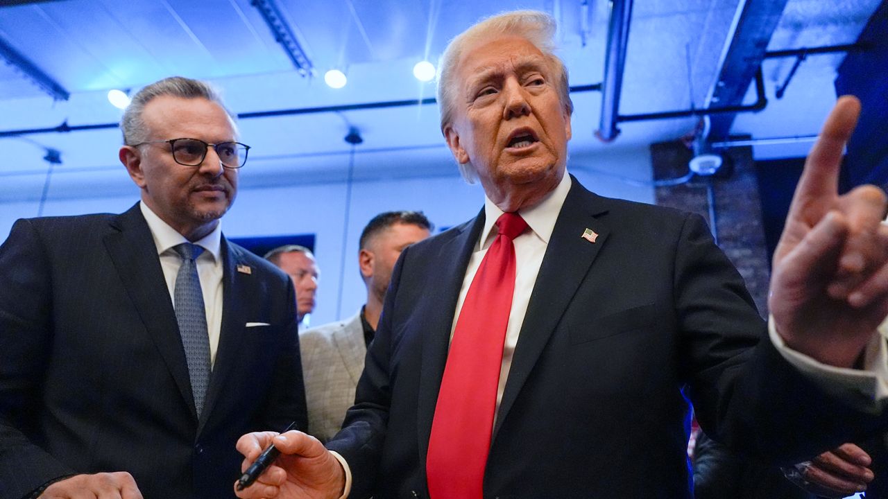 Republican presidential nominee former President Donald Trump signs autographs as Massad Boulos listens during a visit to The Great Commoner, Nov. 1, 2024, in Dearborn, Mich. (AP Photo/Julia Demaree Nikhinson, File)