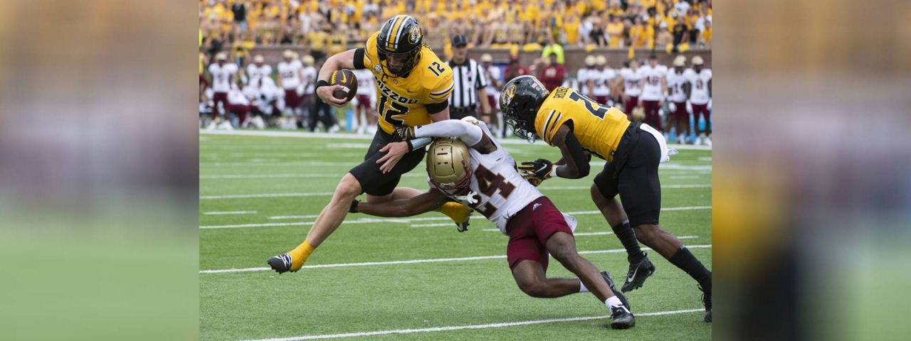 Missouri quarterback Brady Cook (12) jumps over Boston College cornerback Amari Jackson (24) Jamal Roberts, right blocks during the second half of an NCAA college football game, Saturday, Sept. 14, 2024, in Columbia, Mo. Brady scored on the play. (AP Photo/L.G. Patterson)