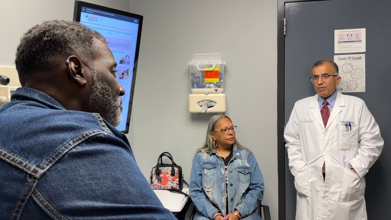 Darnell and his wife Gail sit as the doctor talks to them in a small exam room. 