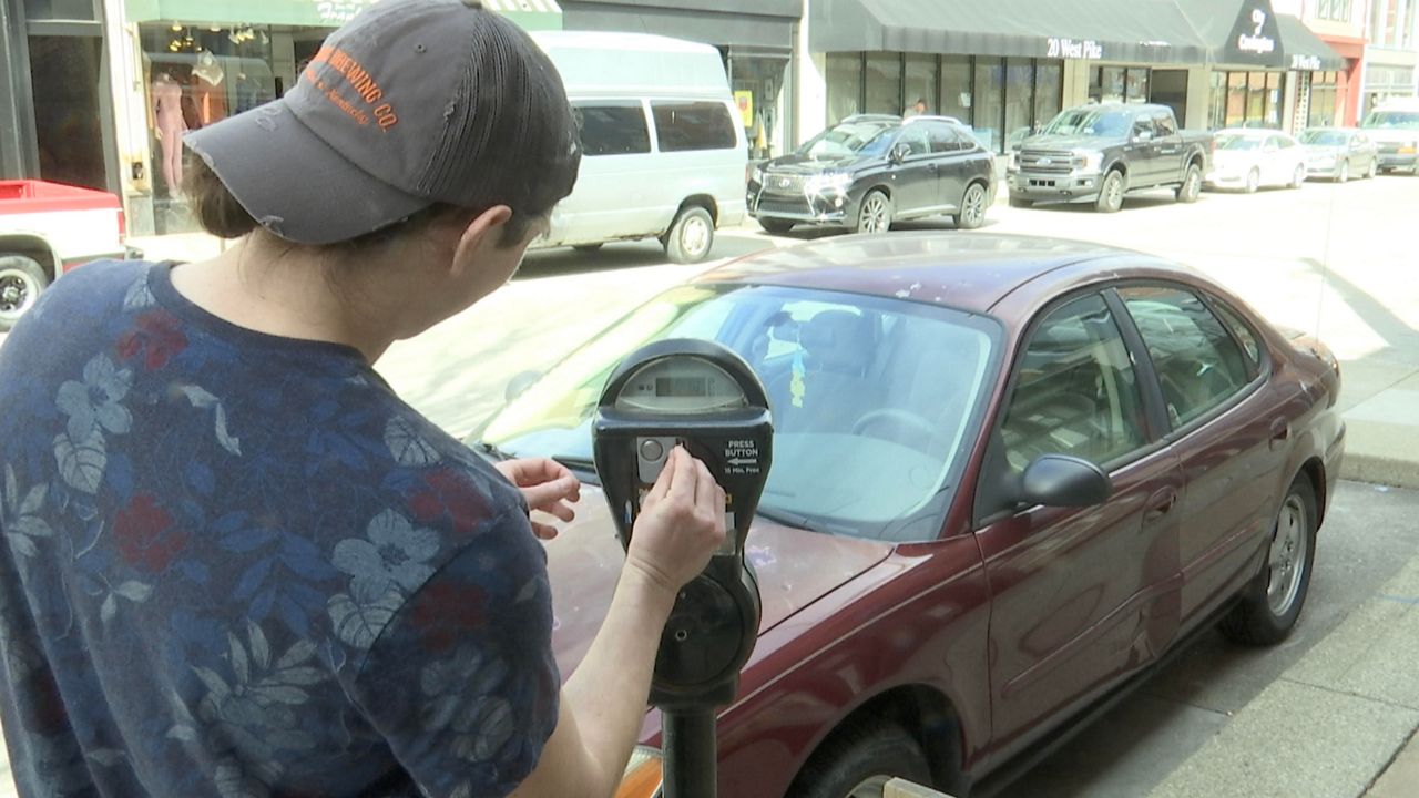 Brendan Jordan filling up a parking meter in downtown Covington (Spectrum News 1/Sam Knef)