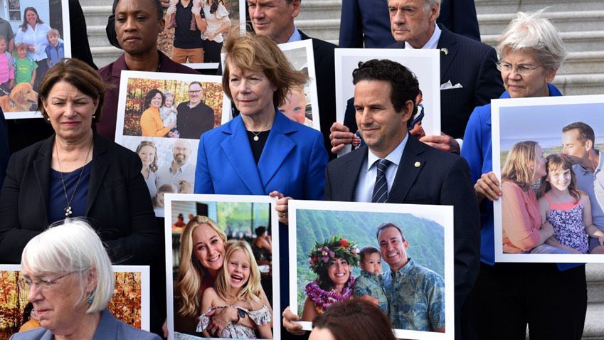 At a press conference prior to Tuesday's Senate vote on the Right to IVF Act, U.S. Sen. Brian Schatz shared the story of a local IVF family—Kelsi Chan, Ruy Cuadra, and their baby Nalu—and held up a poster with their image. (Office of U.S. Sen. Brian Schatz)