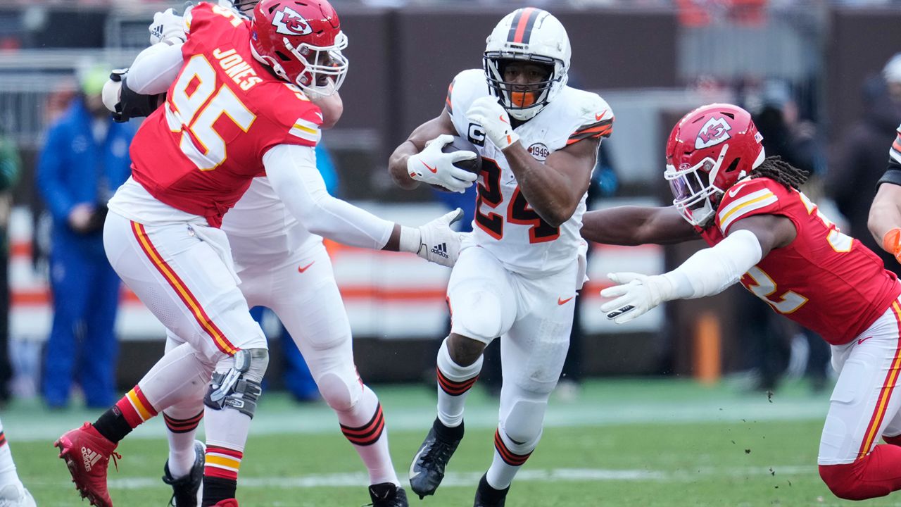 Cleveland Browns running back Nick Chubb, center, carries the ball between Kansas City Chiefs defensive tackle Chris Jones (95) and linebacker Nick Bolton, right, in the first half of an NFL football game in Cleveland, Sunday, Dec. 15, 2024. (AP Photo/Sue Ogrocki)