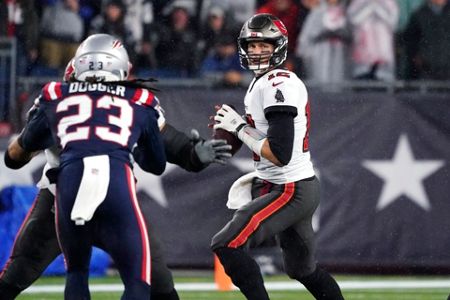 Tampa Bay Buccaneers quarterback Tom Brady (12) meets with New England  Patriots long snapper Jo …