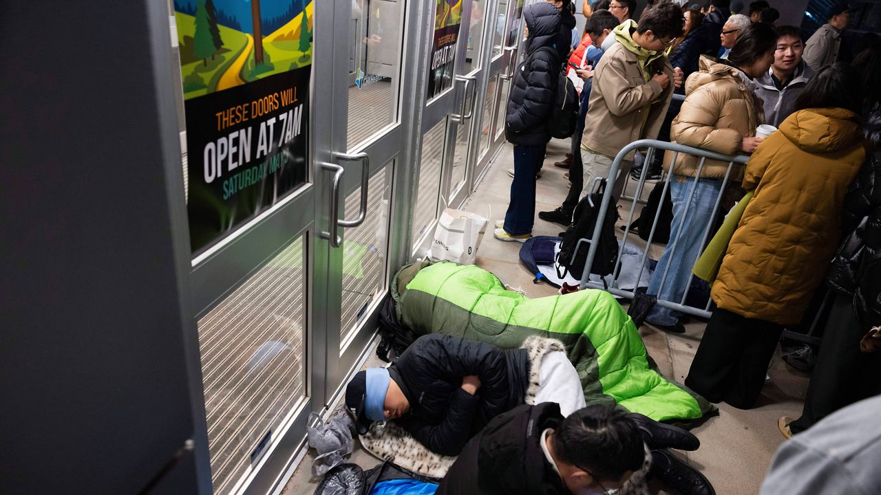 From front, shareholders Haibo Liu, Liyang Jiang and Cheng Guo of China rest in sleeping bags outside CHI Health Center Omaha for the Berkshire Hathaway annual meeting Saturday, May 3, 2025, in Omaha, Neb. The group arrived at 11 p.m. the night before to retain a spot at the front of the line. (AP Photo/Rebecca S. Gratz)