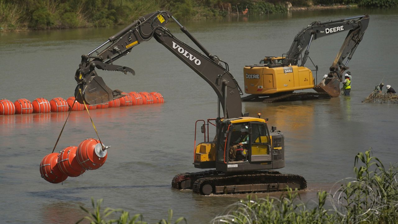 Workers continue to deploy large buoys to be used as a border barrier along the banks of the Rio Grande in Eagle Pass, Texas, Wednesday, July 12, 2023. The floating barrier is being deployed in an effort to block migrants from entering Texas from Mexico. (AP Photo/Eric Gay)