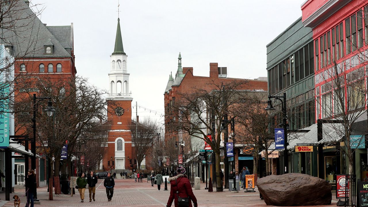 Pedestrians walk down Church Street in Burlington, Vt., Wednesday, March 11, 2020. (AP Photo/Charles Krupa)