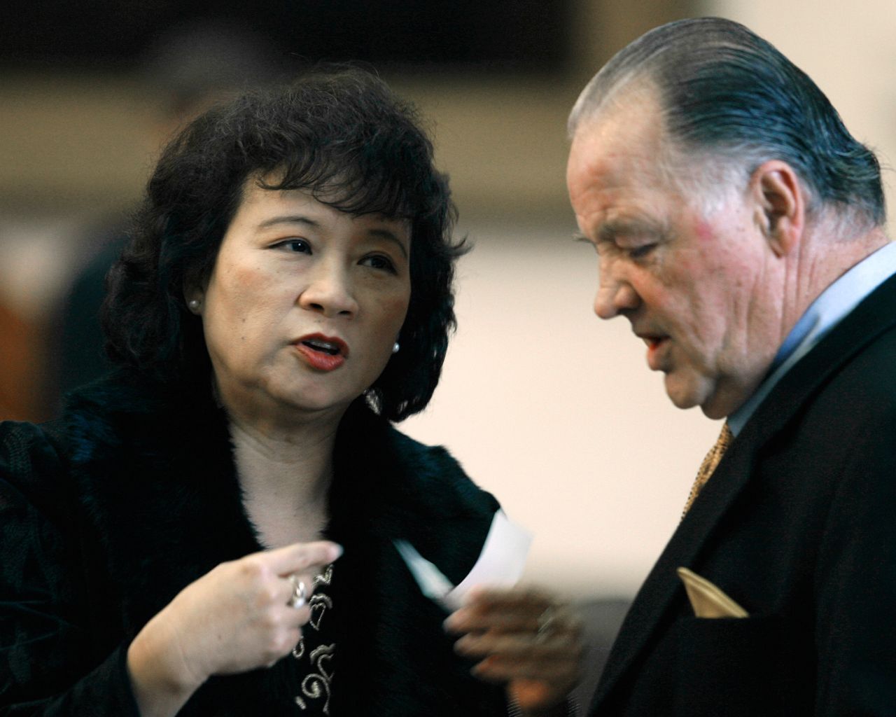 Rep. Angie Chen Button, R-Dallas, left, talks with Rep. Tommy Merritt, R-Longview, right, during the session in the Texas House of Representatives Thursday, Jan. 15, 2009, in Austin, Texas. (AP Photo/Harry Cabluck)