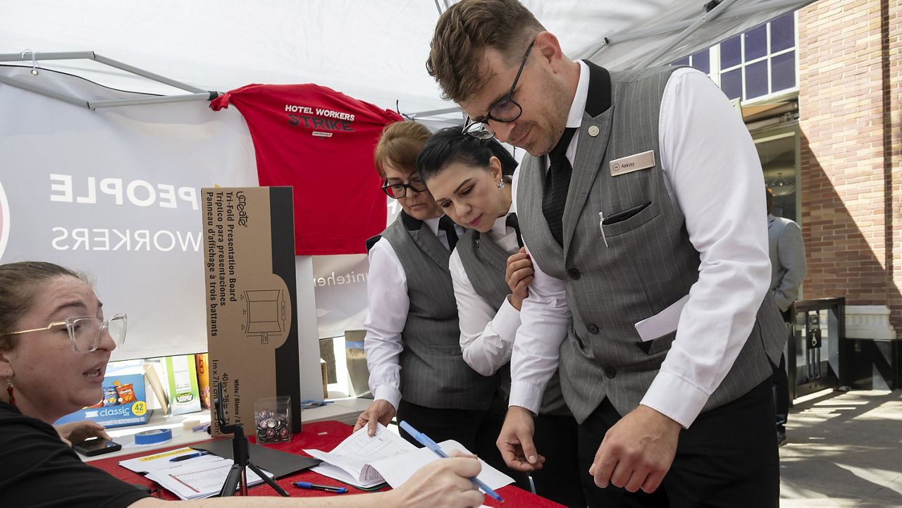 Sheraton Grand Hotel workers Lupe Ventura, center, and Alex Ivanitsky, right, who are represented by hospitality workers union United Here Local 49, participate in a strike authorization vote in Sacramento, Calif., Wednesday, Sept. 11, 2024. (Paul Kitagaki Jr./The Sacramento Bee via AP)