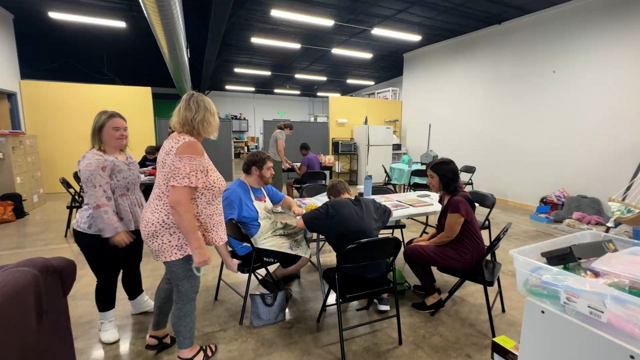 Clients at Camp Createability work in a makeshift space after flooding caused damage to parts of the building. (Spectrum News 1/Natalie Sopyla)