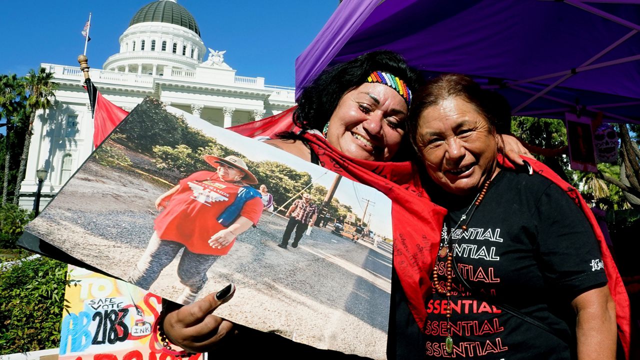 Farmworkers Cynthia Burgos, left and Teresa Maldonado, right, hug after Gov. Gavin Newsom signed a bill aimed at making it easier for farmworkers to unionize in Sacramento, Calif., Sept. 28, 2022. (AP Photo/Rich Pedroncelli, File)
