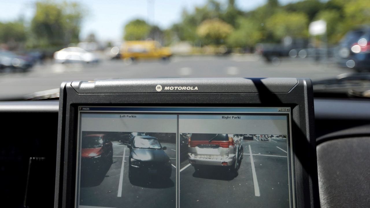 In this Spet.17, 2014 file photo a police vehicle reads the license plates of cars in a parking lot in San Marcos, Calif. (AP Photo/Gregory Bull,File)